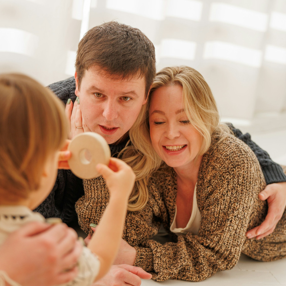 Parents looking at child showing round object
